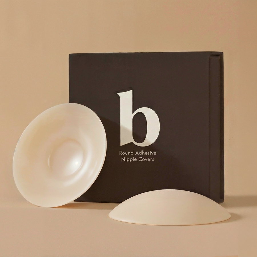 Round adhesive nipple covers with packaging on a beige background
